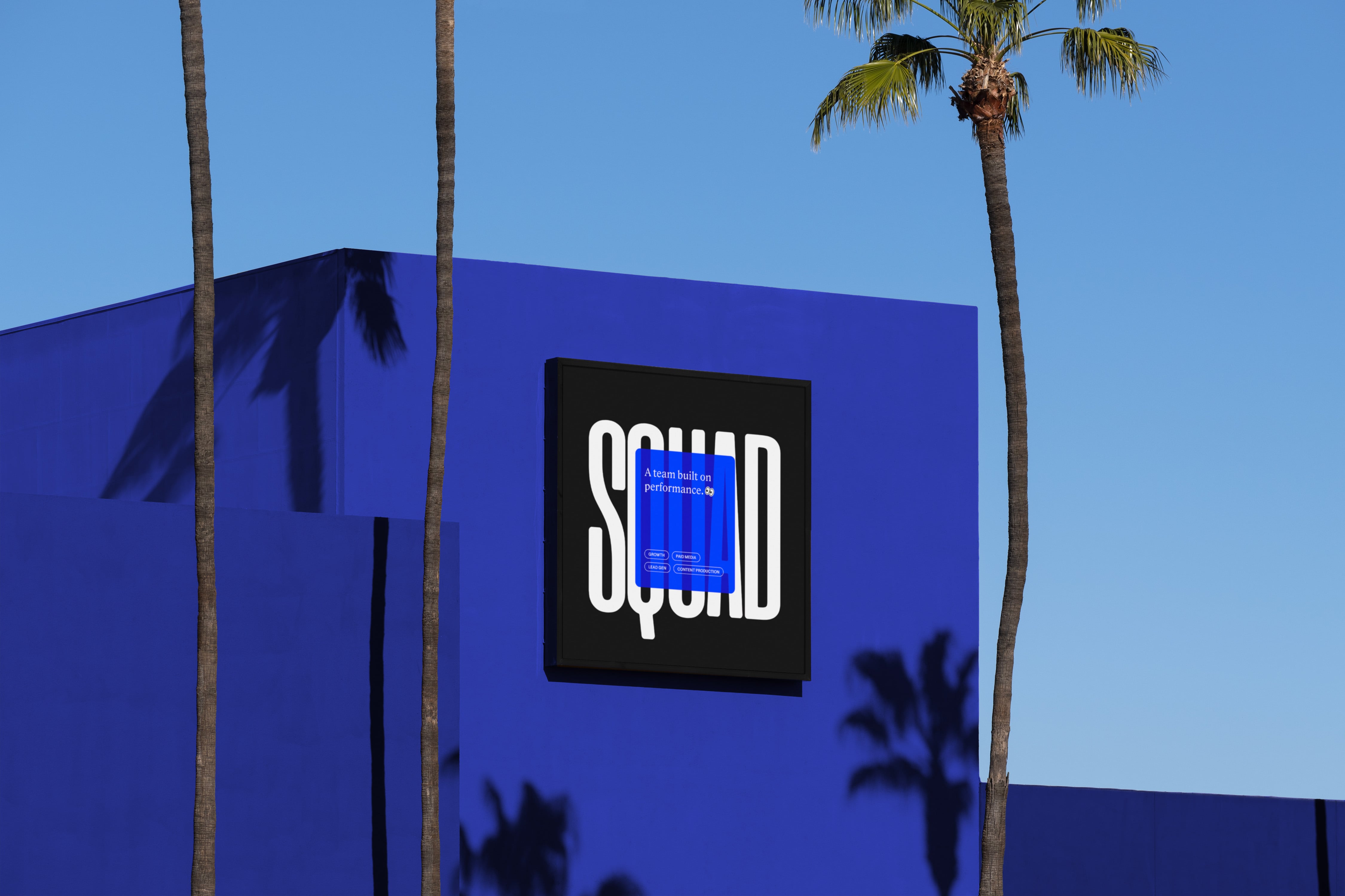 Squad Media black billboard on a blue wall