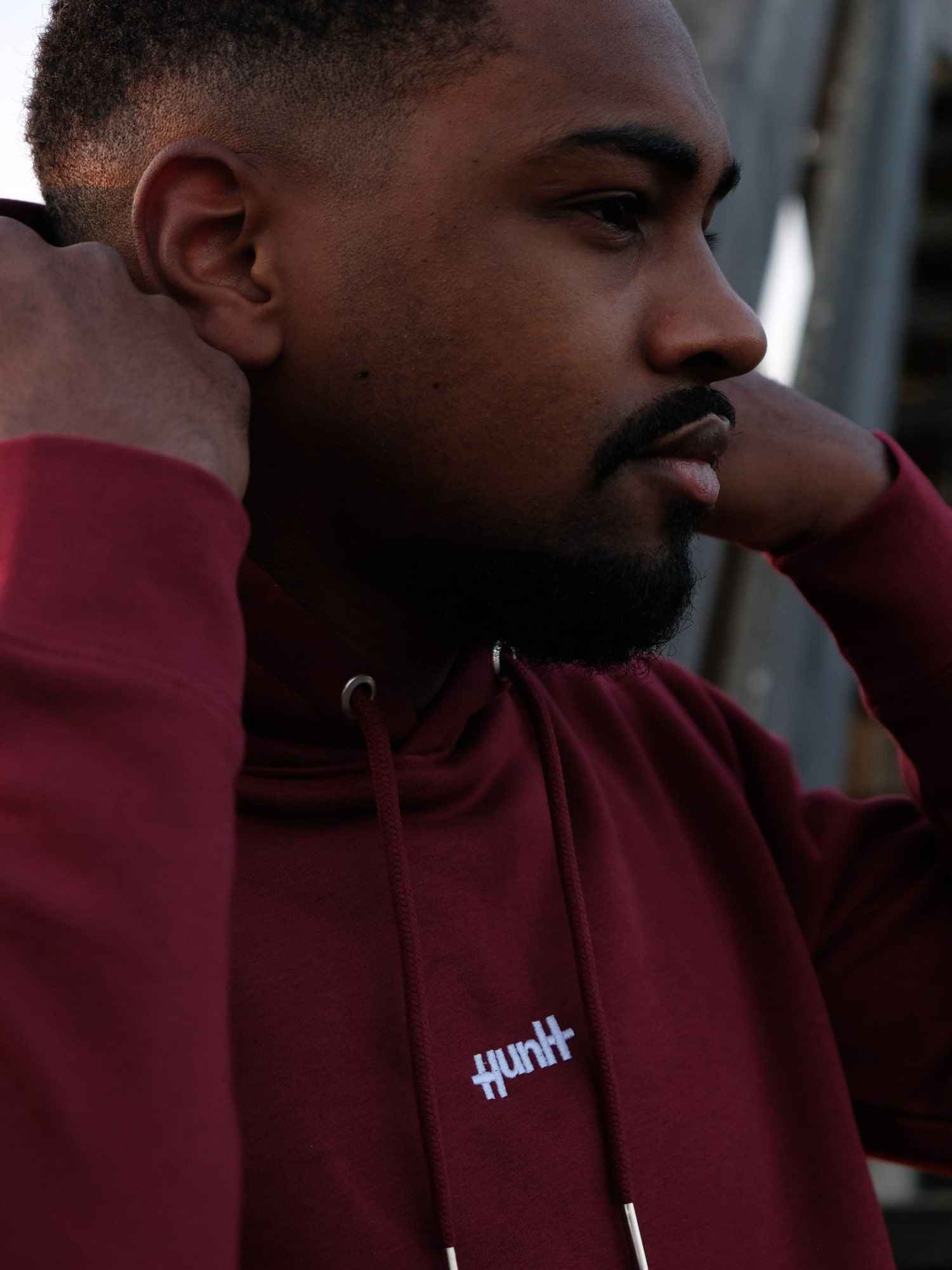 Man wearing a red hoodie with a white Huntt logo on it