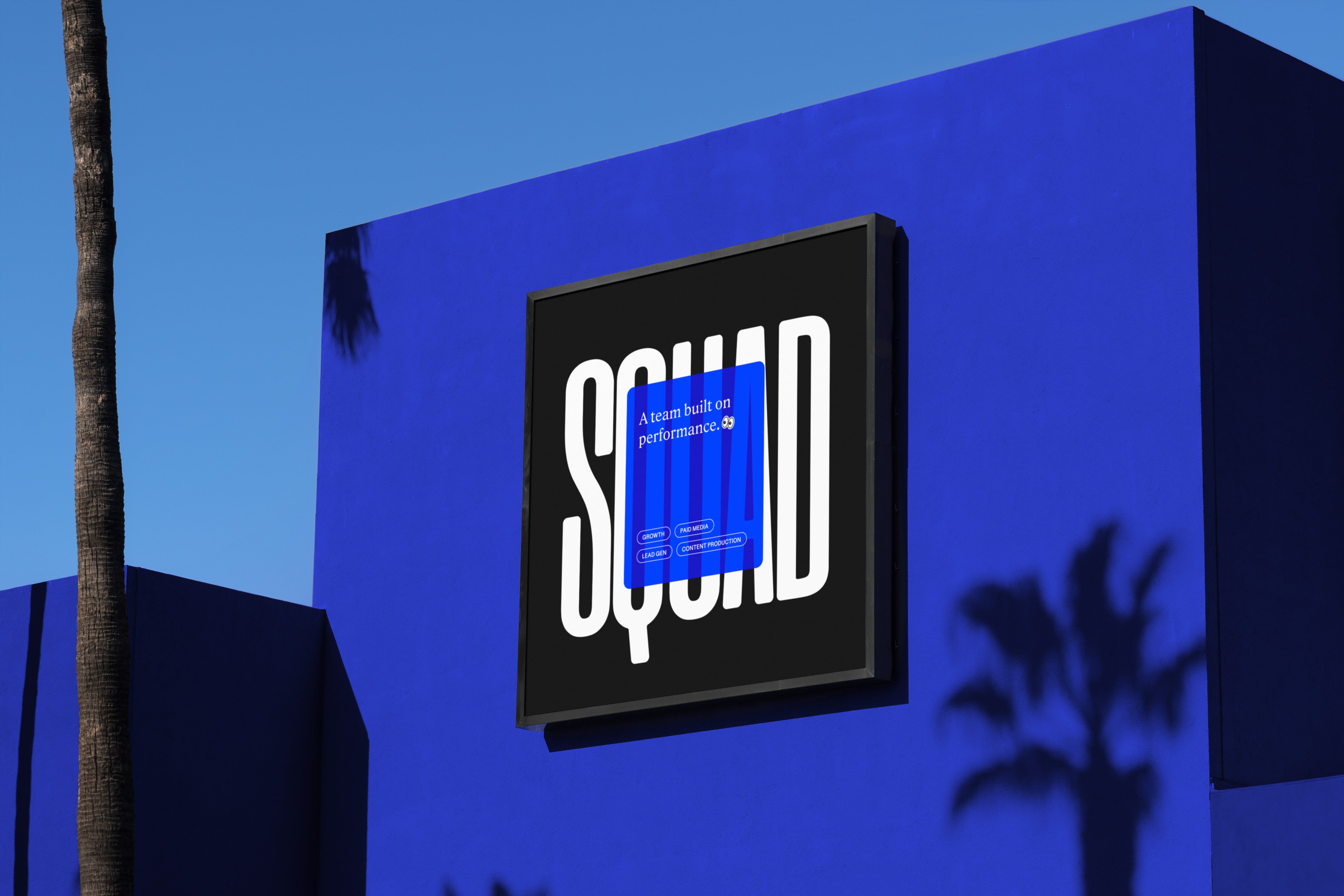 Squad Media black billboard on a blue wall